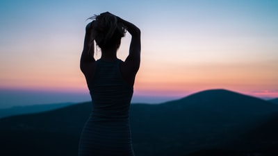 轮廓的女人站在山峰
